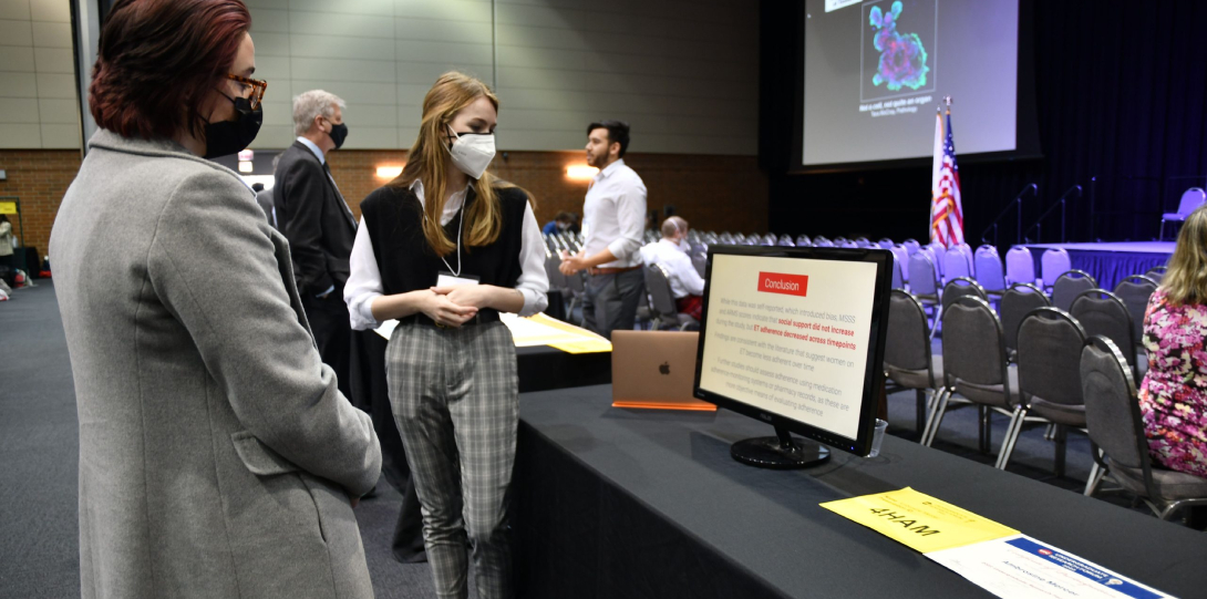 A student presents their research to a guest at the 2022 Undergraduate Research Forum